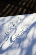 An acrylic tabletop easel placed on a white surface with shadows cast over them.