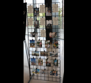 A black photo display grate with multiple pockets, each holding a photograph, displayed indoors.