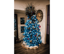 Decorated blue Christmas tree with ornaments in a room setting.