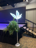 Butterfly Lamp in front of a stage with greenery arrangement beside it.