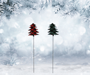 Two Christmas tree-shaped garden stakes in a snowy landscape with blurred trees in the background.