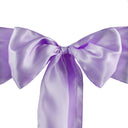 A close-up image of a lavender satin chair sash with a bow in the center.