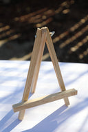 A small wooden tabletop easel displayed on a table.