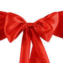 A red satin chair sash tied in a bow in the center, with a smooth, solid red color background.