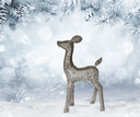 Decorative deer figure in a snowy landscape with pine branches.