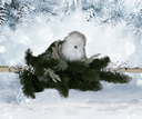 Snowy owl perched on a branch with a snowy background