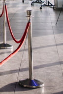 Metal stanchion with red rope on a tiled floor