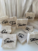 Square stone tiles with numbers engraved on a white surface