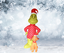 Inflatable figure of a character in a red outfit with a green face, standing in a snowy landscape.