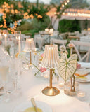 Decorative table setting with lampshades and candles at an outdoor event.